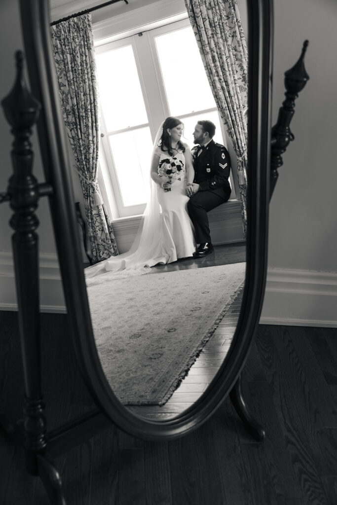 ride and groom reflected in a full-length mirror, sharing a private, joyous moment