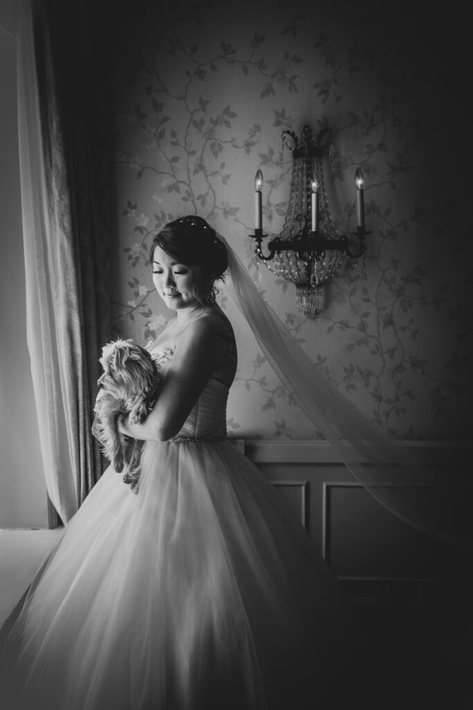 bride having a moment with dog before the ceremony by the beautiful window light