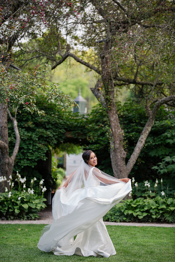 Bride twirling in the garden at Langdon Hall after first look—veil floating, candid portrait