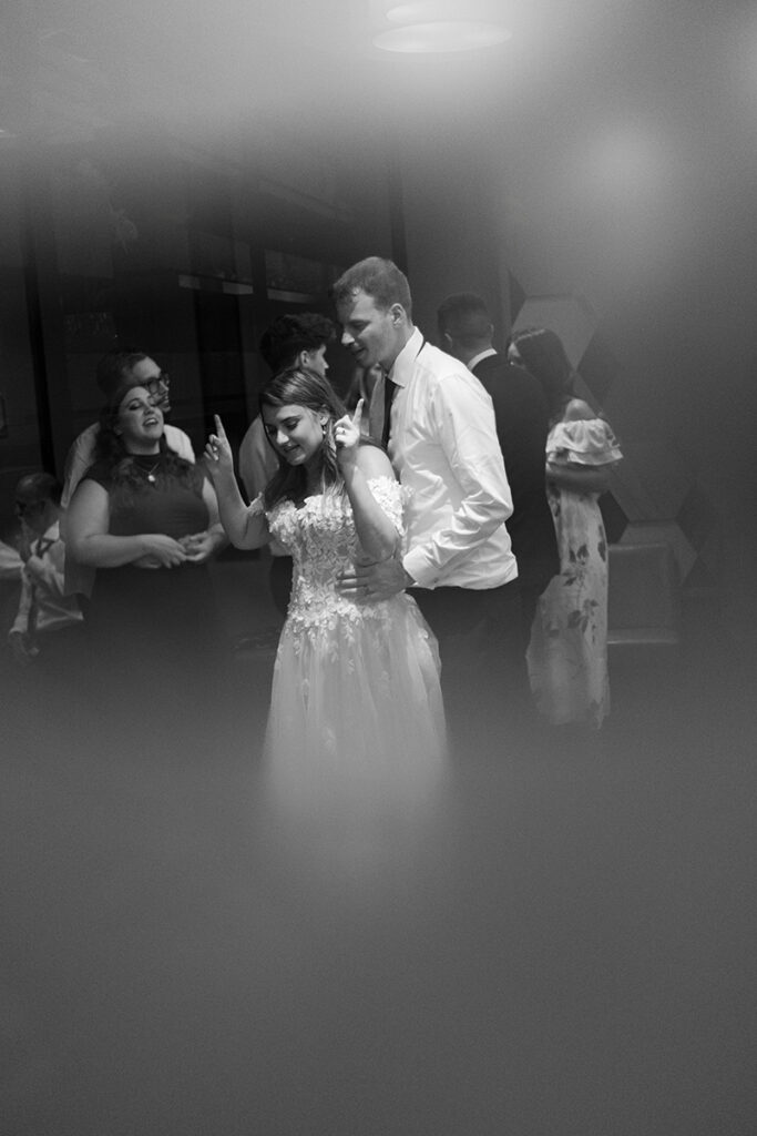 Hands up, big laugh on the dance floor—candid reception moment.